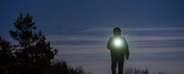 guy holding a solar flashlight at night